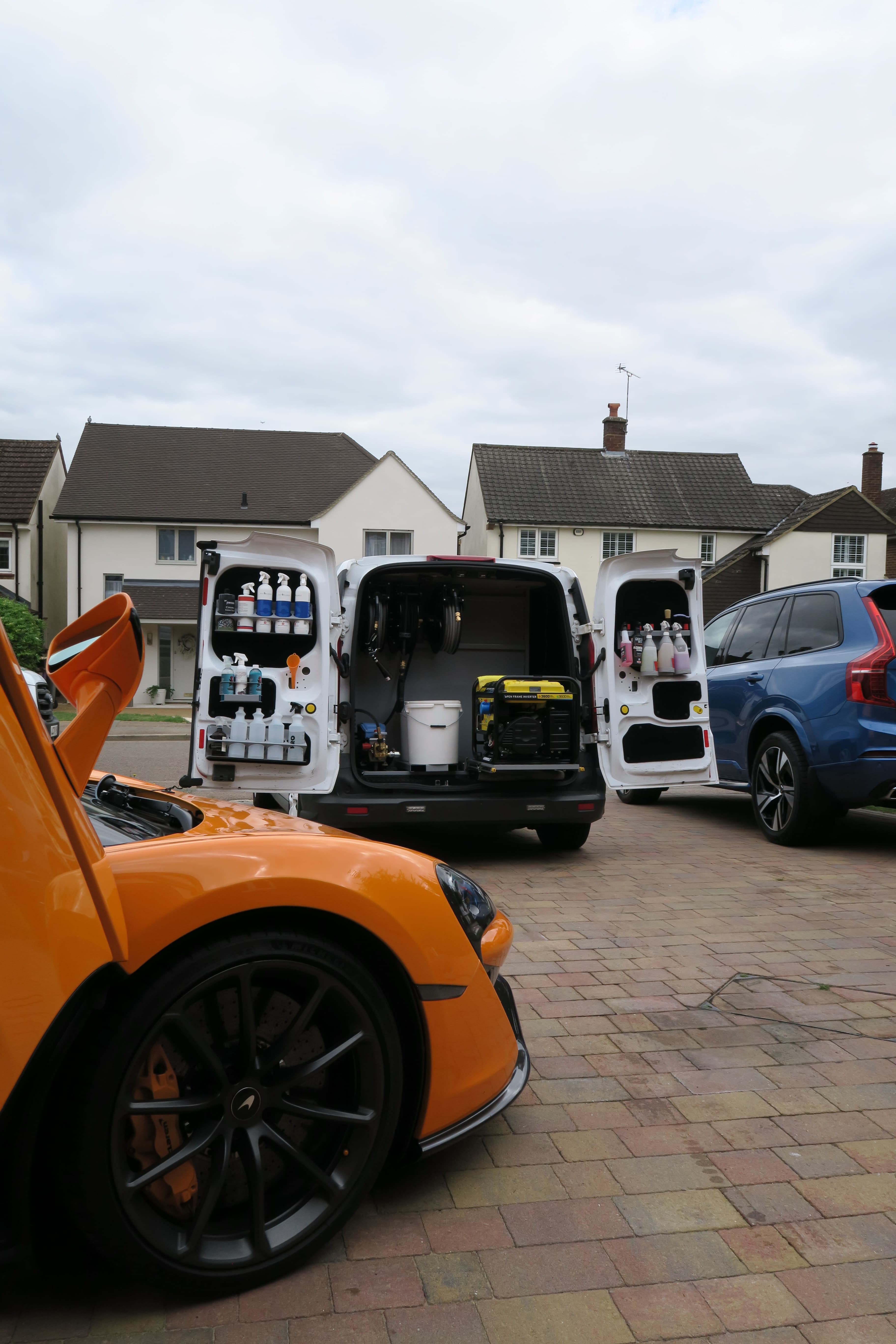 Mobile valeting van beside an orange McLaren on a driveway